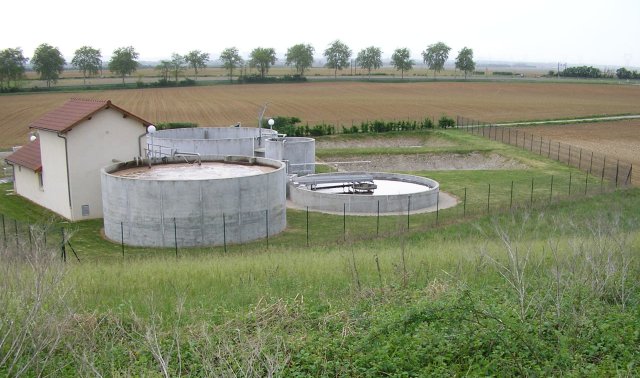 Figure 5: STEP à boues activées en milieu rural (à gauche le bassin d'aération, à droite le clarificateur). Les eaux traitées sont infiltrées dans les deux bassins d'infiltration (au fond, à droite)